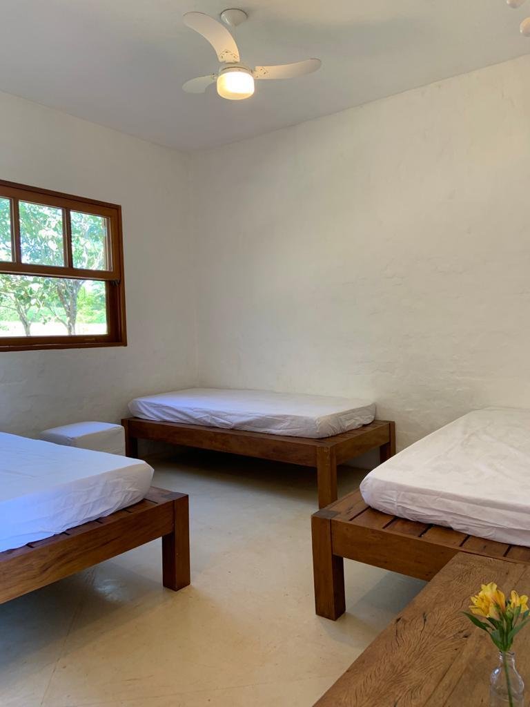 Quarto claro com camas e ventilador